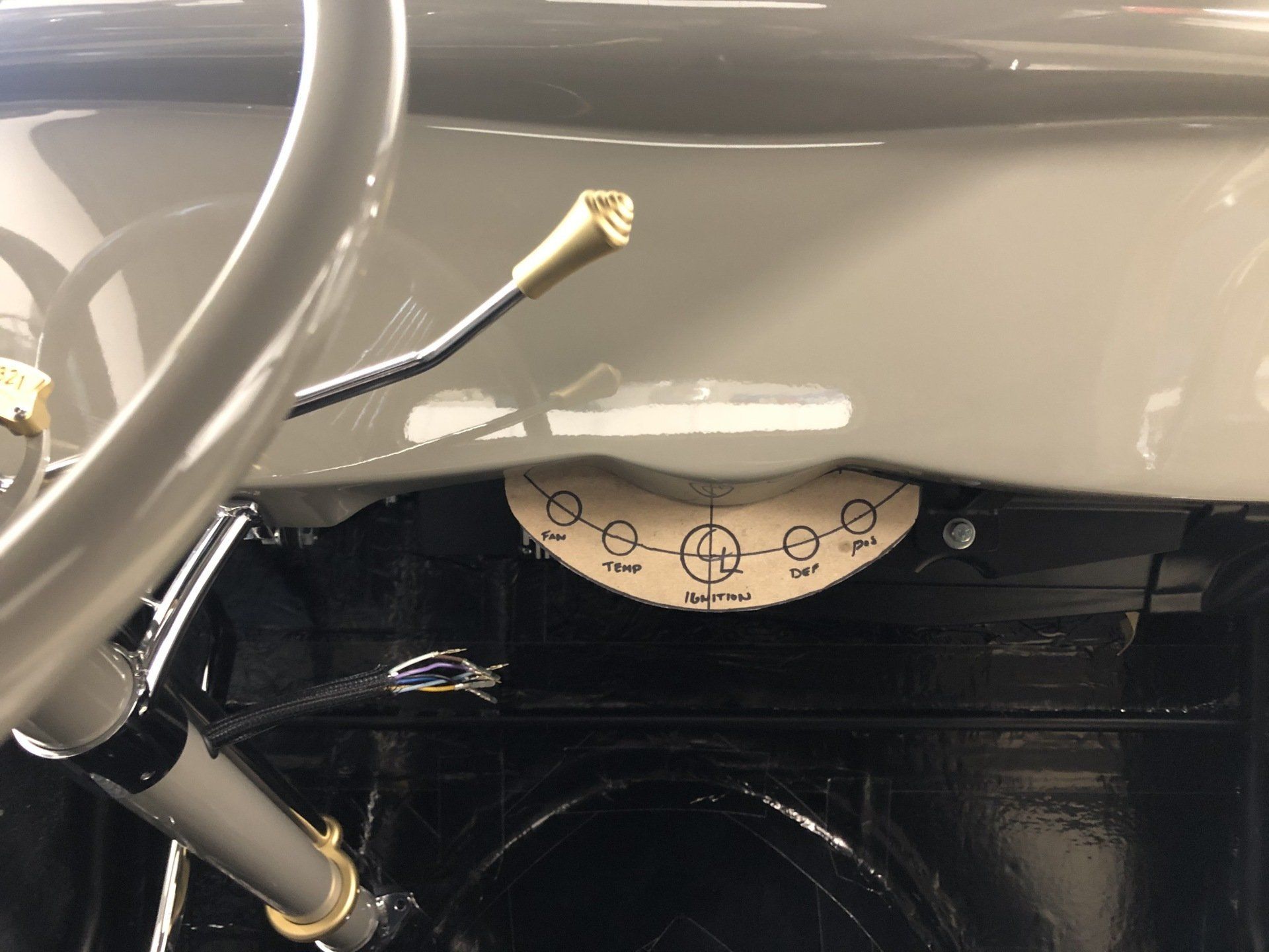 Close-up of a gray machine interior with a circular adjustment dial and metal tubing