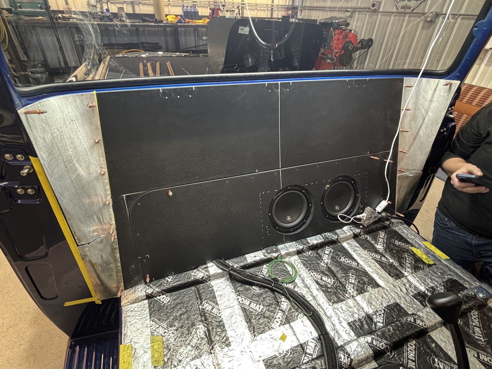 Large black insulated panel with two circular ports on a workbench in an industrial shop