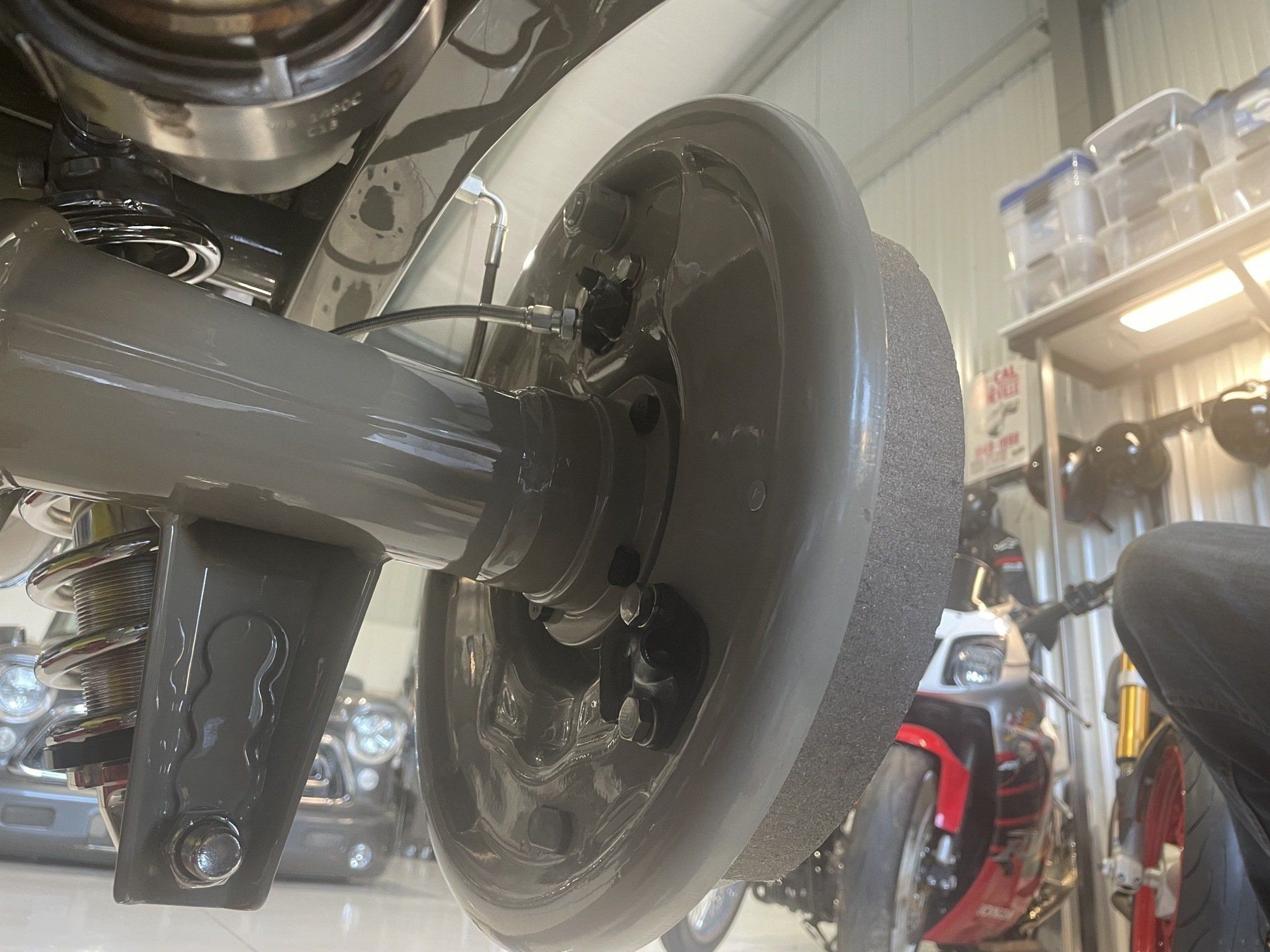 Close-up of a motorcycle rear wheel and suspension in a garage or workshop