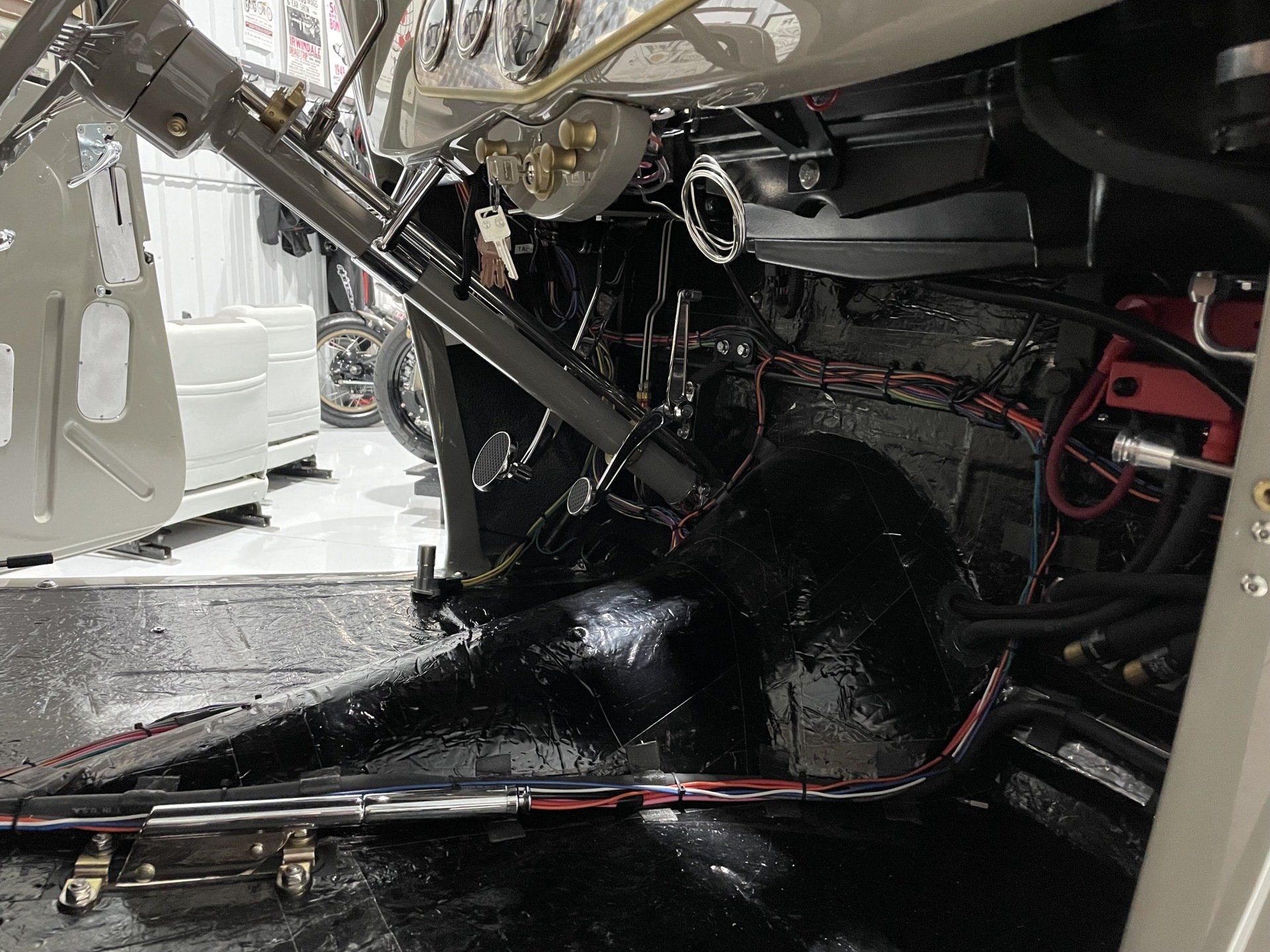 Damaged vehicle interior with exposed wiring, broken dashboard, and debris on the floor