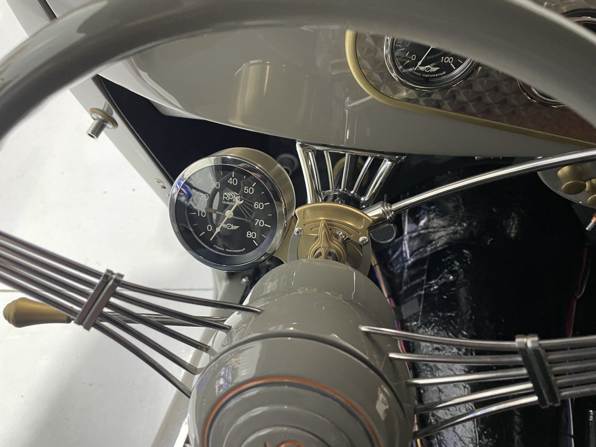 Close-up of a vintage car engine with chrome details and side pipes.