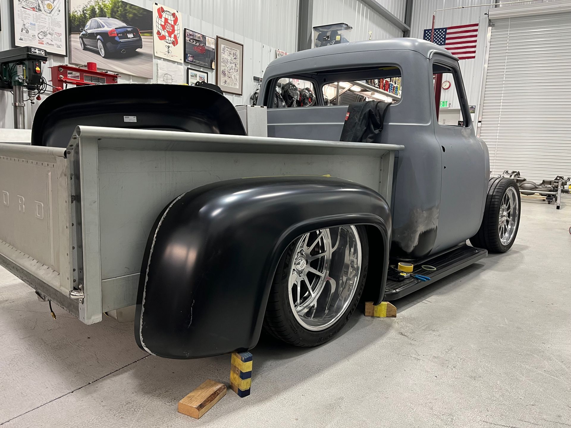Custom gray vintage pickup truck with black fenders in a workshop garage