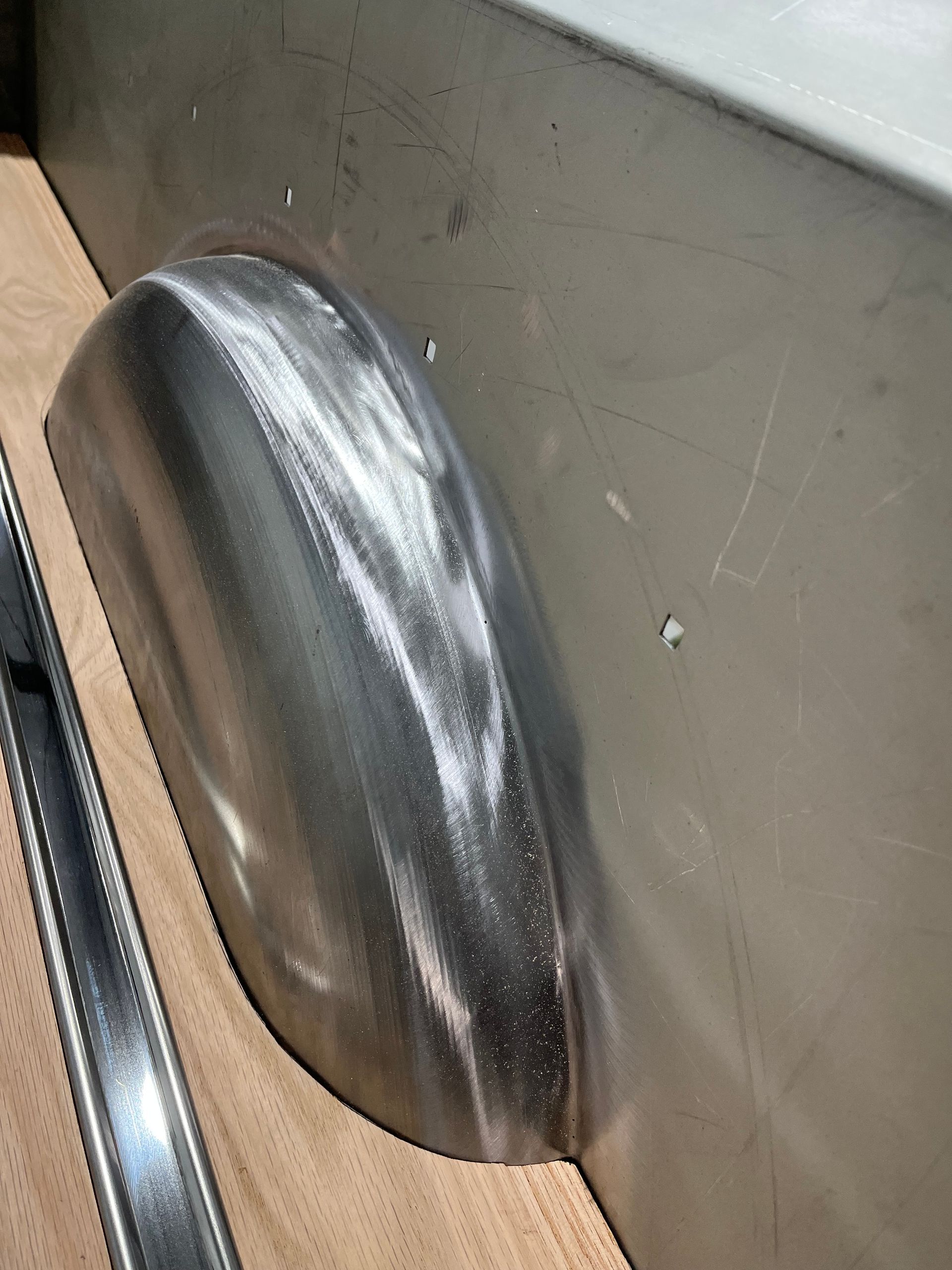 Close-up of a metal vent or speaker grille on a gray wall panel