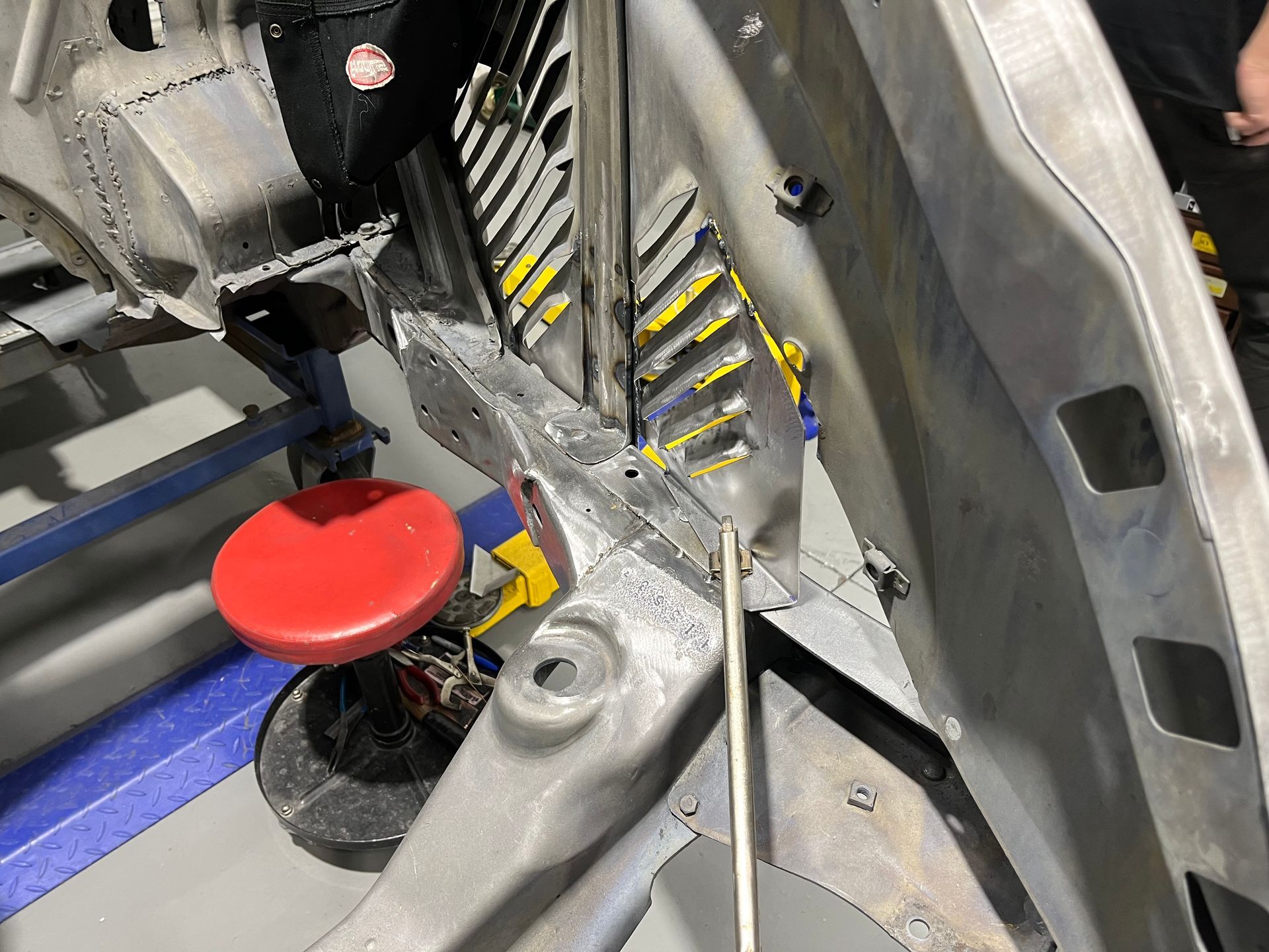 Red button on a metal machine panel with yellow-black hazard stripes and silver components