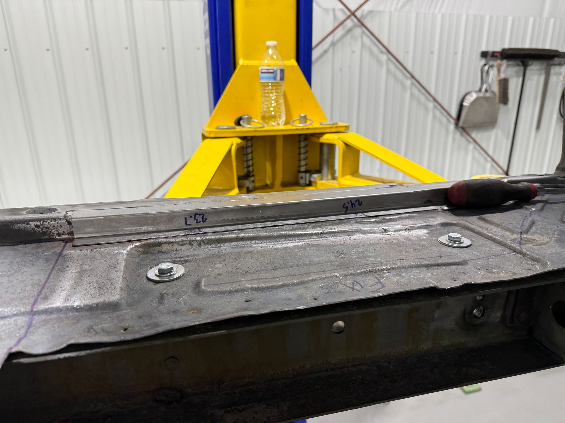 Yellow industrial machine mounted on a black metal platform inside a workshop