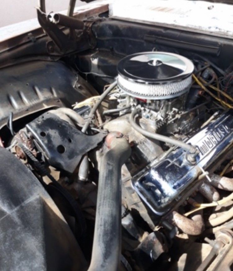 Chrome car engine with air filter and hoses in an open hood compartment