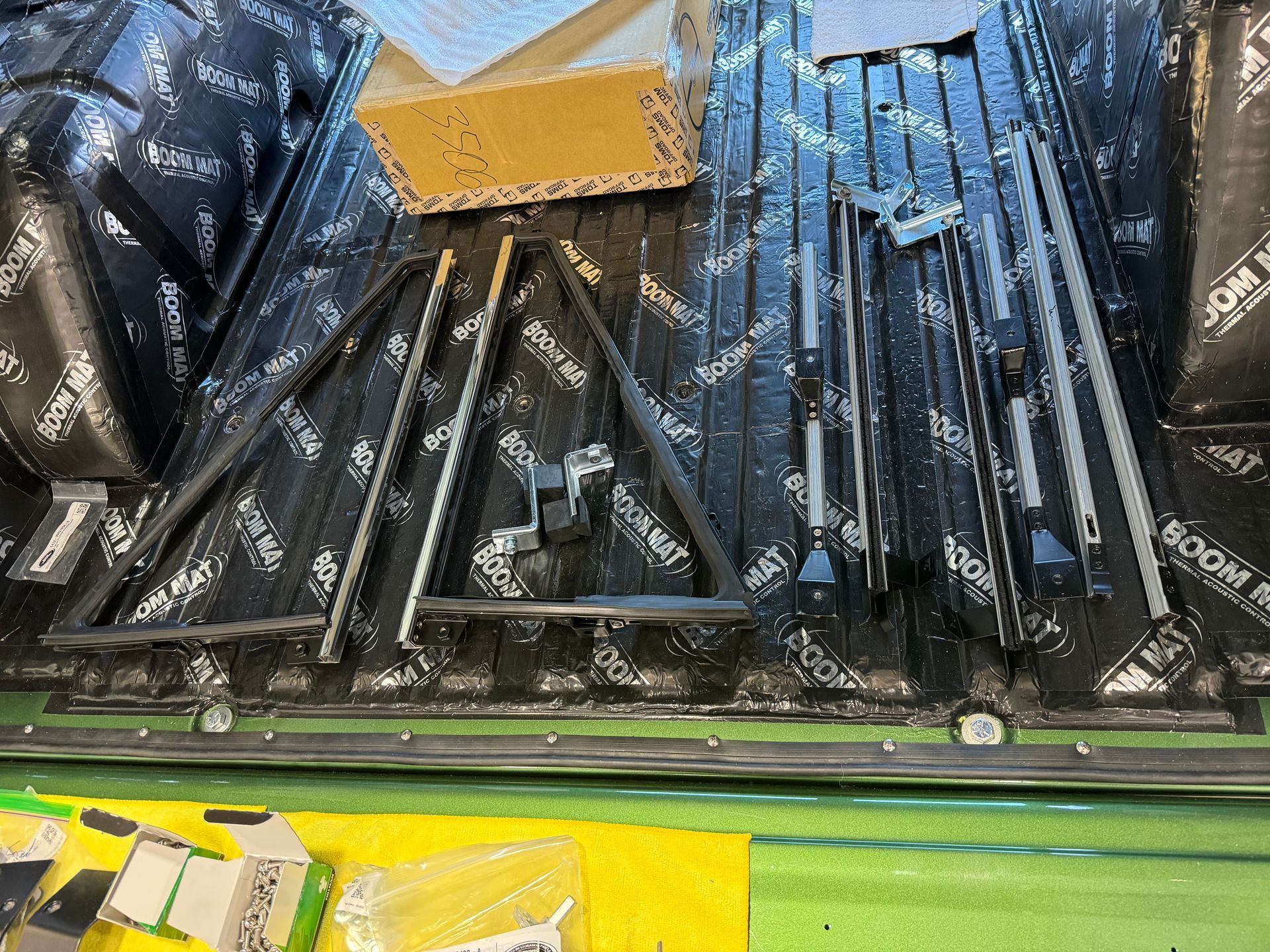 Stacked black packaged items with a yellow box on a warehouse conveyor line