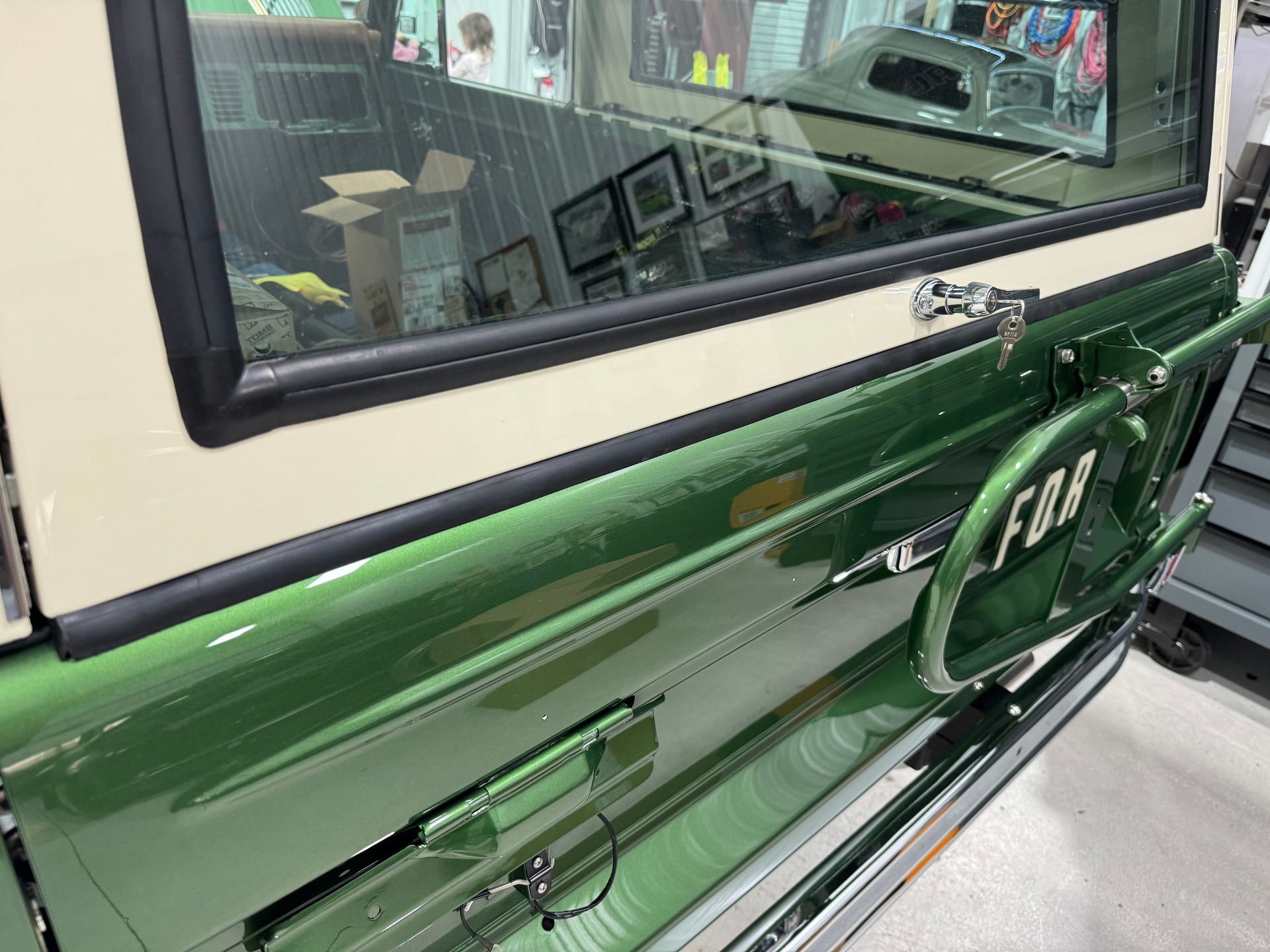Green FJR motorcycle side view with windshield and mirror indoors
