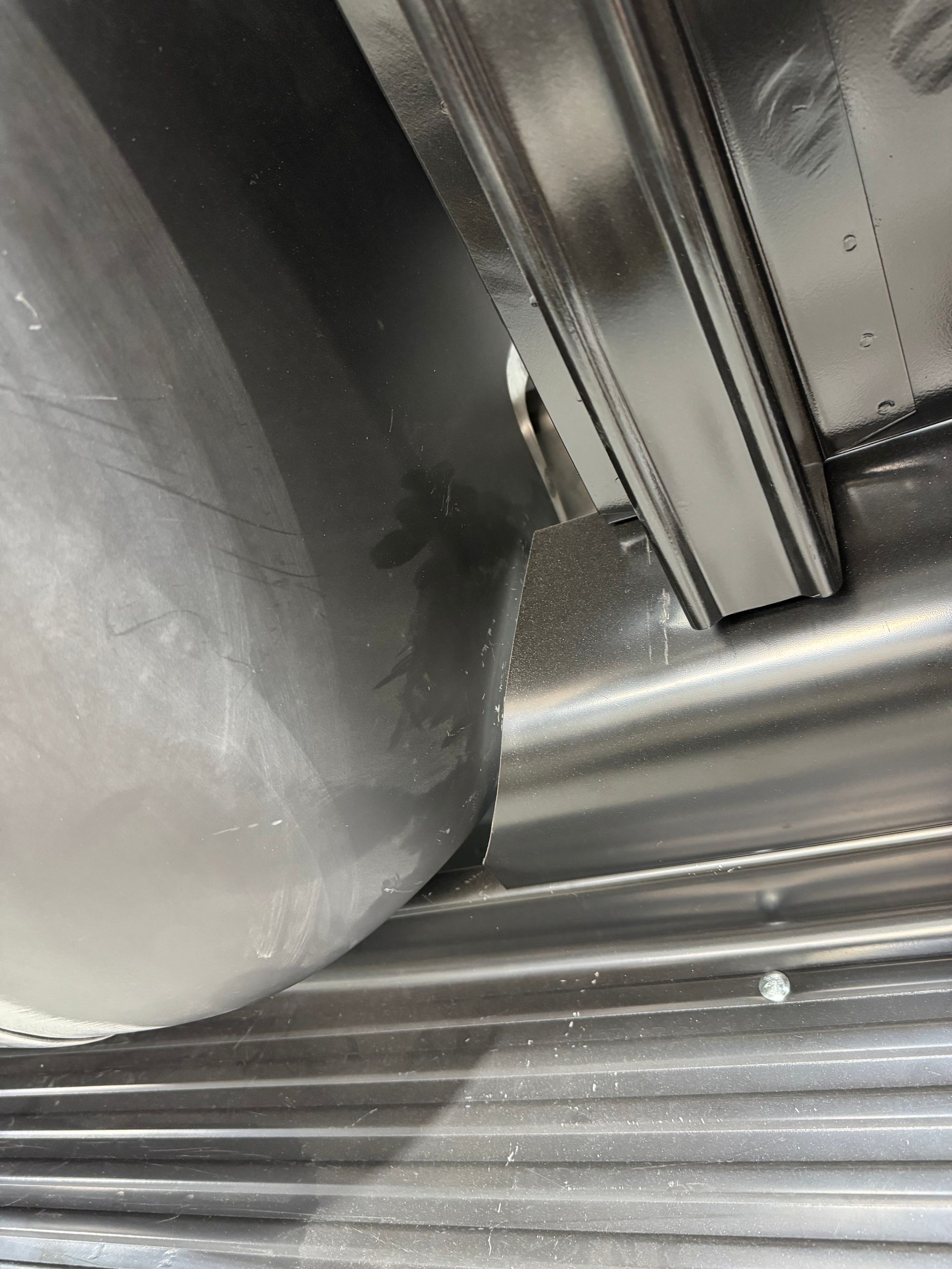 Close-up of a metal cylindrical component and grooved metal surface inside an industrial machine