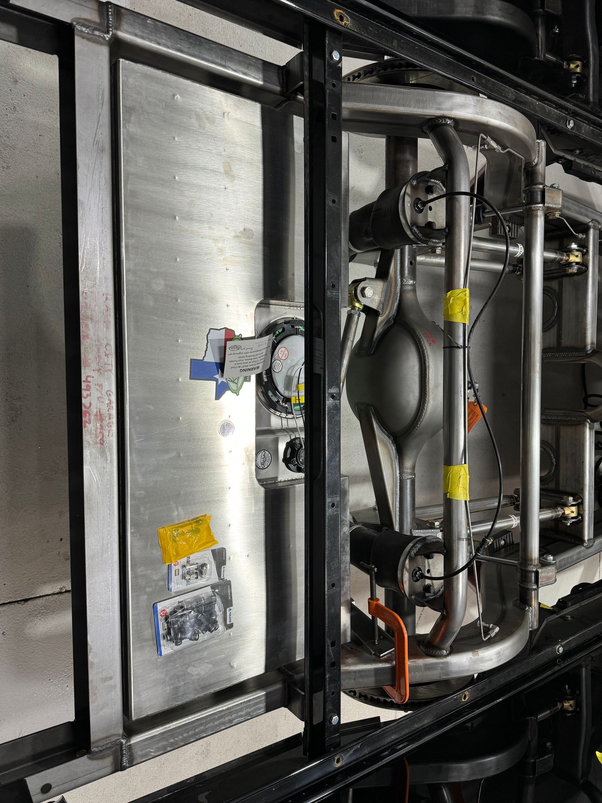 Industrial machinery inside a metal frame with pipes, wiring, and labels.