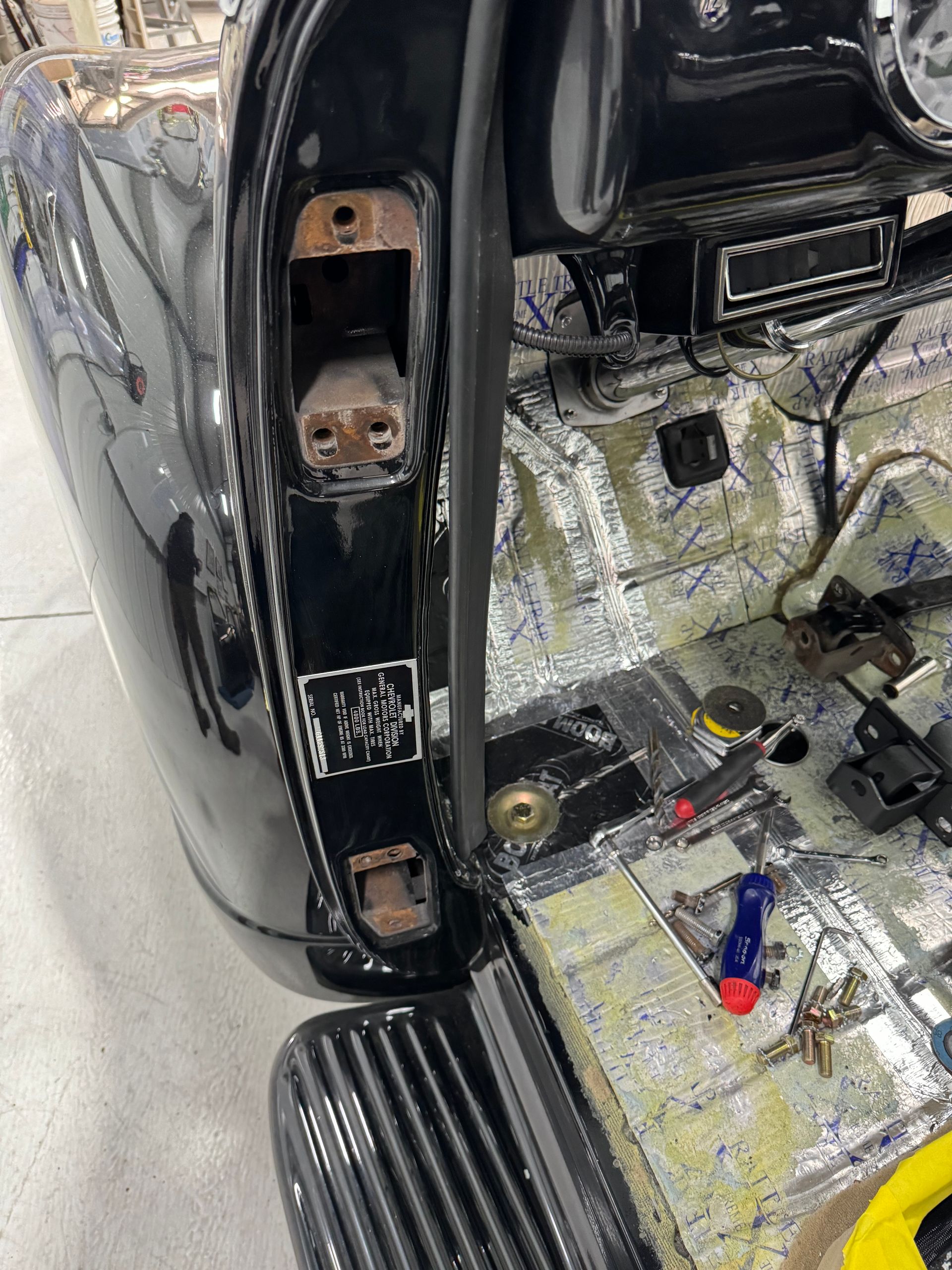 Car interior with rear door panel removed, showing exposed wiring and sound-deadening insulation.
