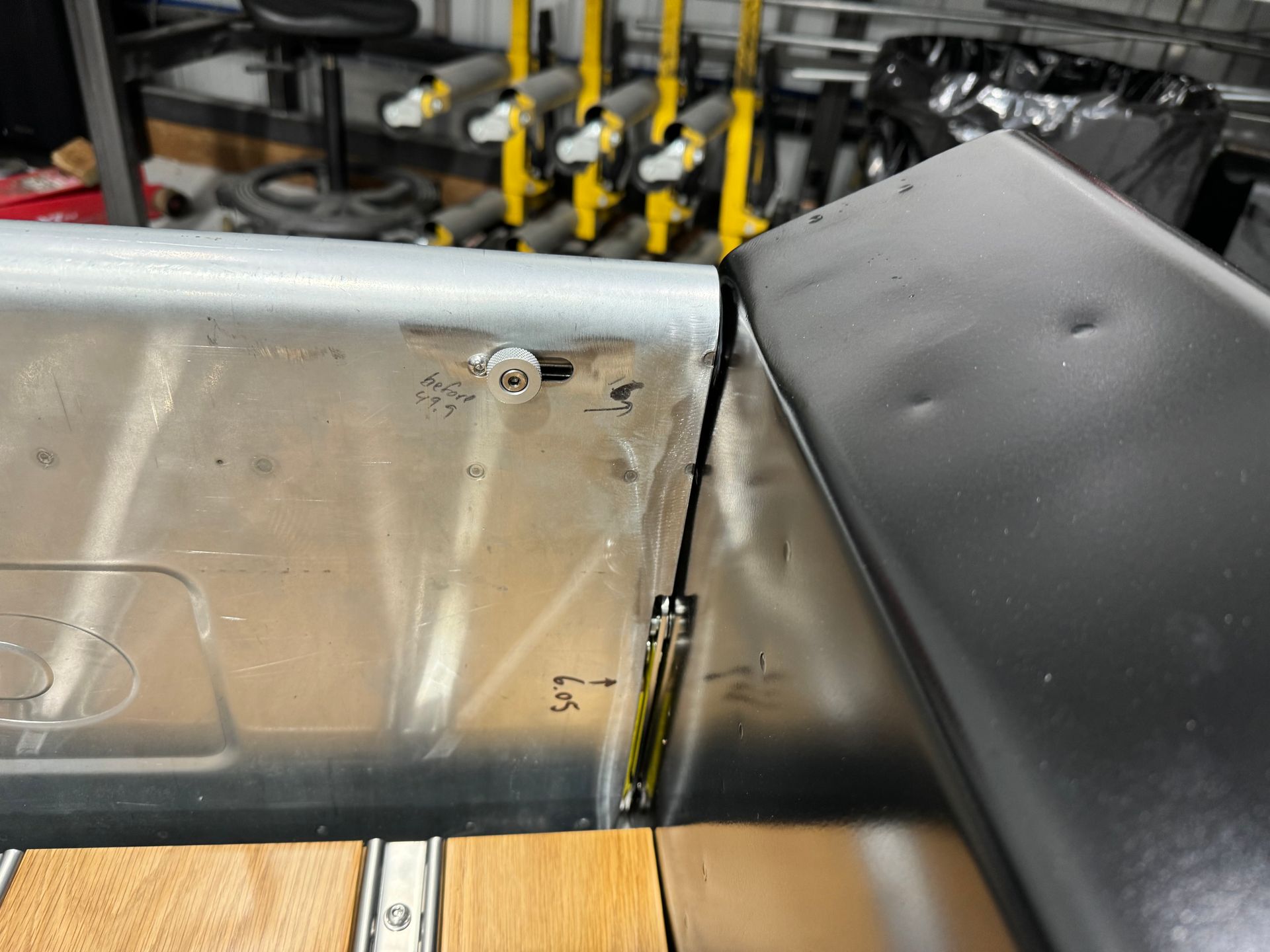 Metal industrial equipment with a clear panel, black housing, and yellow valves in the background