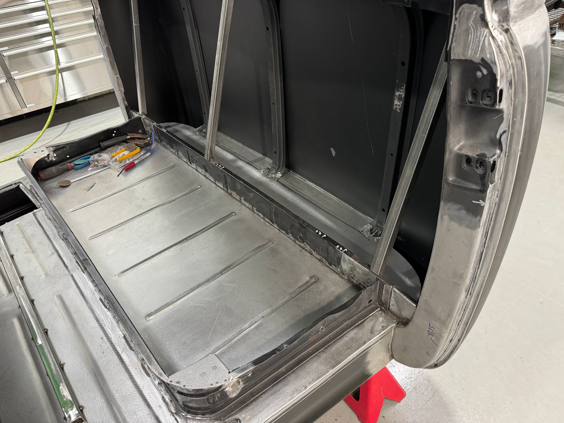Open aircraft cargo bay with metal floor panels and exposed interior framing.