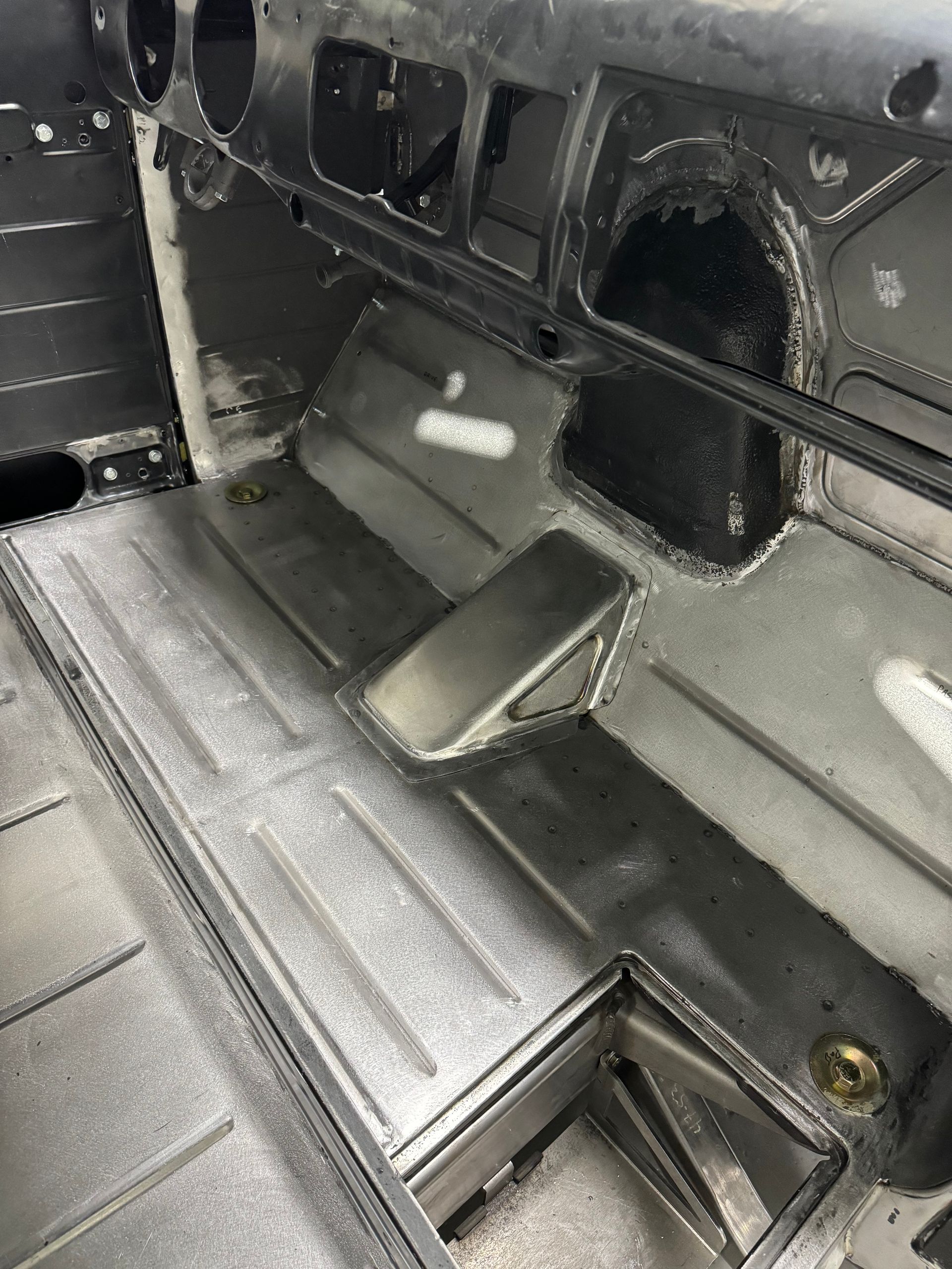 Black vehicle interior with a folded center console and ribbed floor mat