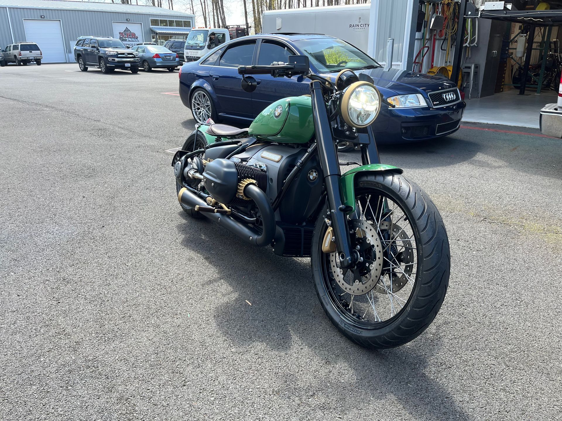 Black motorcycle parked on a street with cars and storefronts in the background