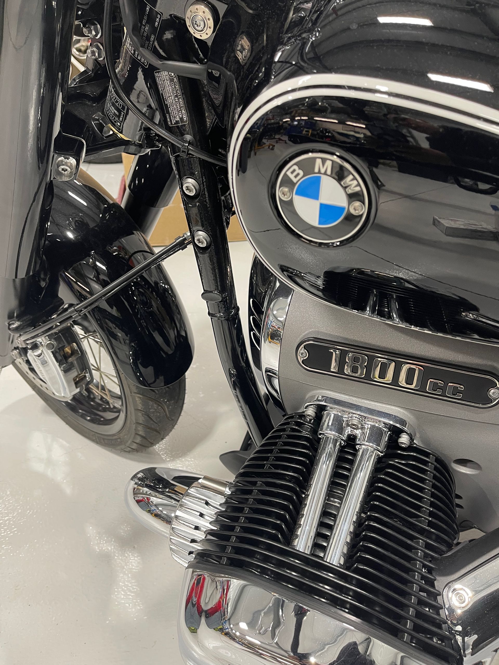 Close-up of a black BMW motorcycle engine and side panel with chrome details.