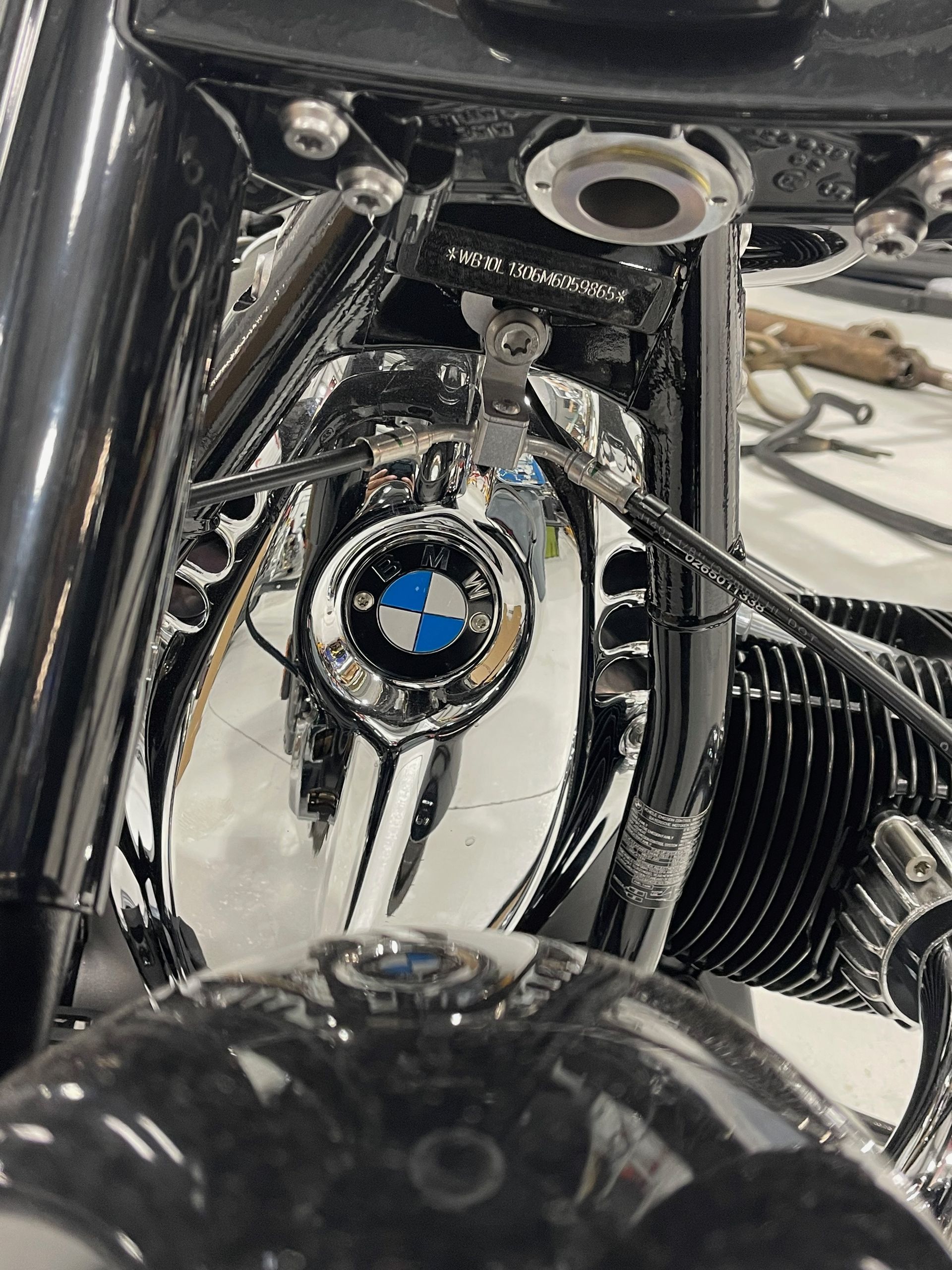 Close-up of a black BMW motorcycle front emblem and chrome engine details