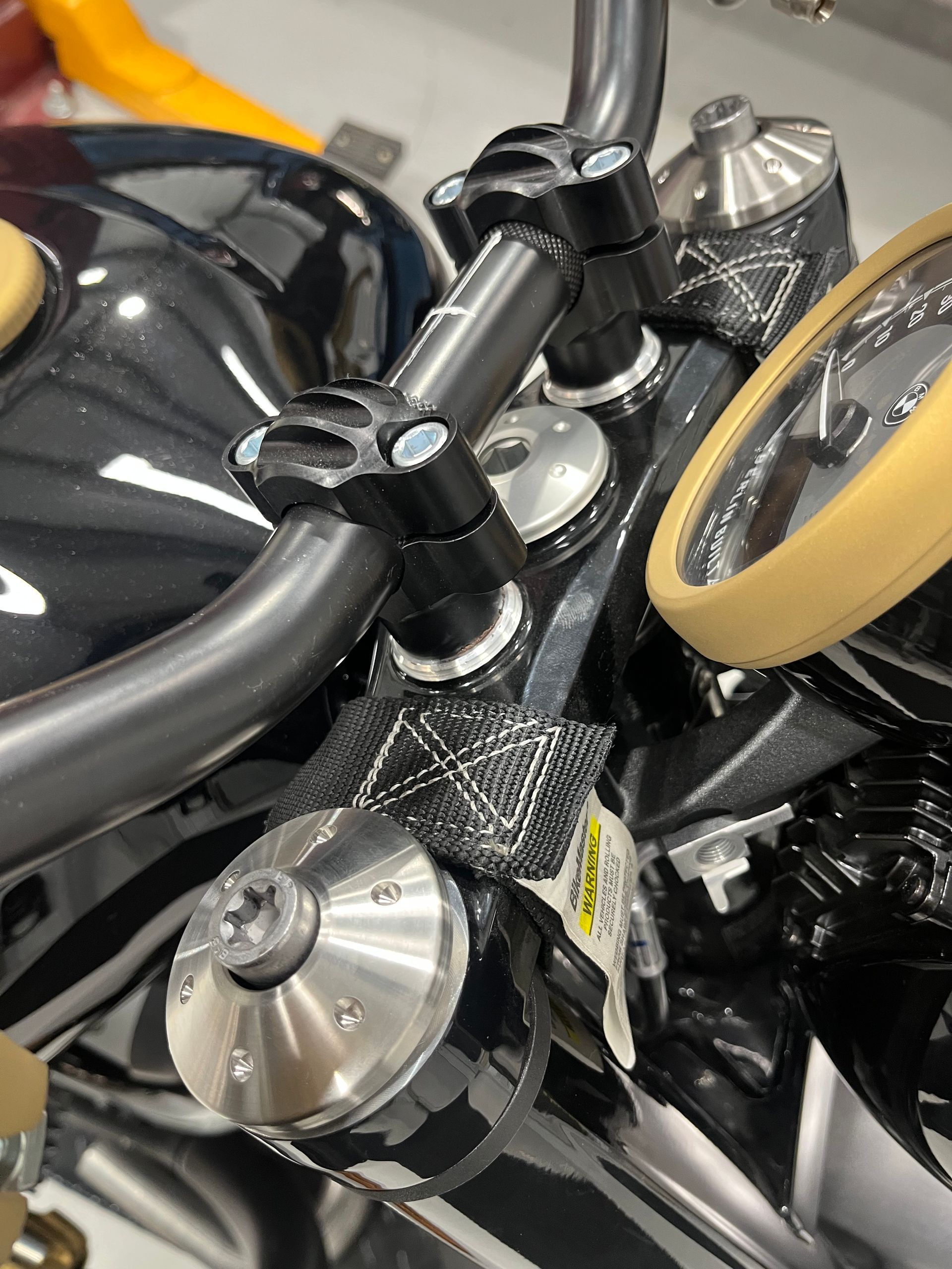 Close-up of a black and silver motorcycle handlebar with yellow accents and chrome details