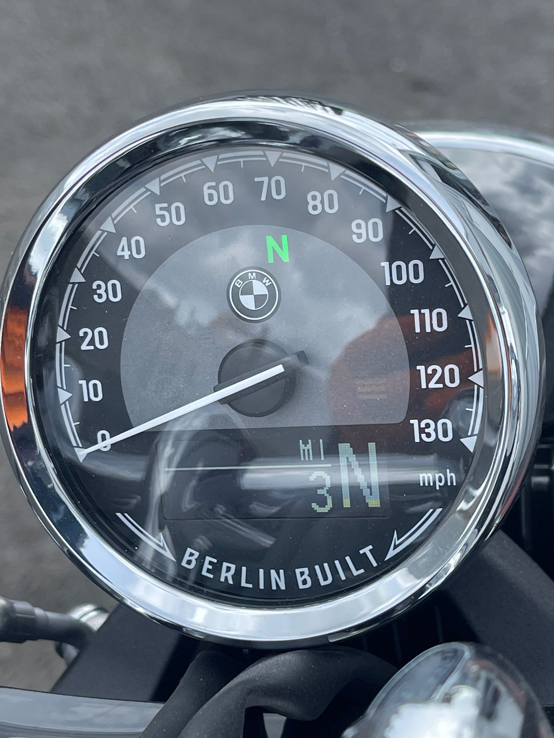 Close-up of a BMW Berlin Bulli speedometer showing about 31 mph on a motorcycle dashboard