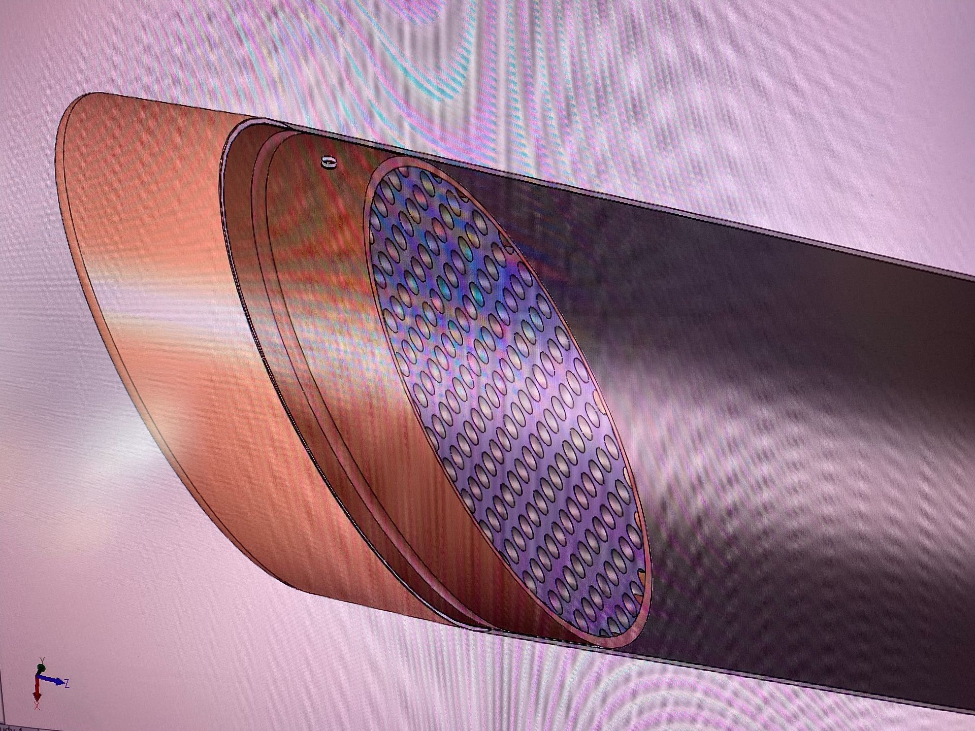 Cutaway of a copper-and-black cylindrical mechanical component showing a purple mesh interior.