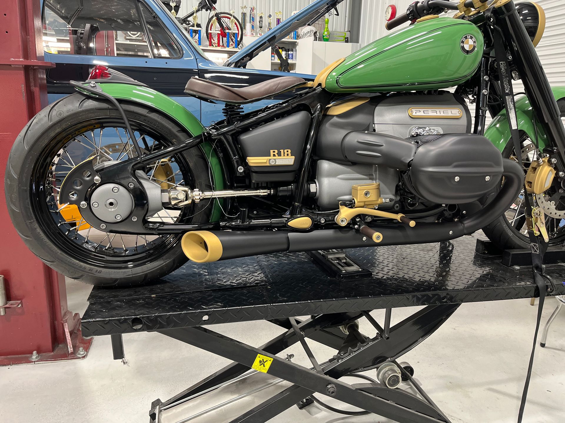 Green-and-black motorcycle on a maintenance lift in a workshop