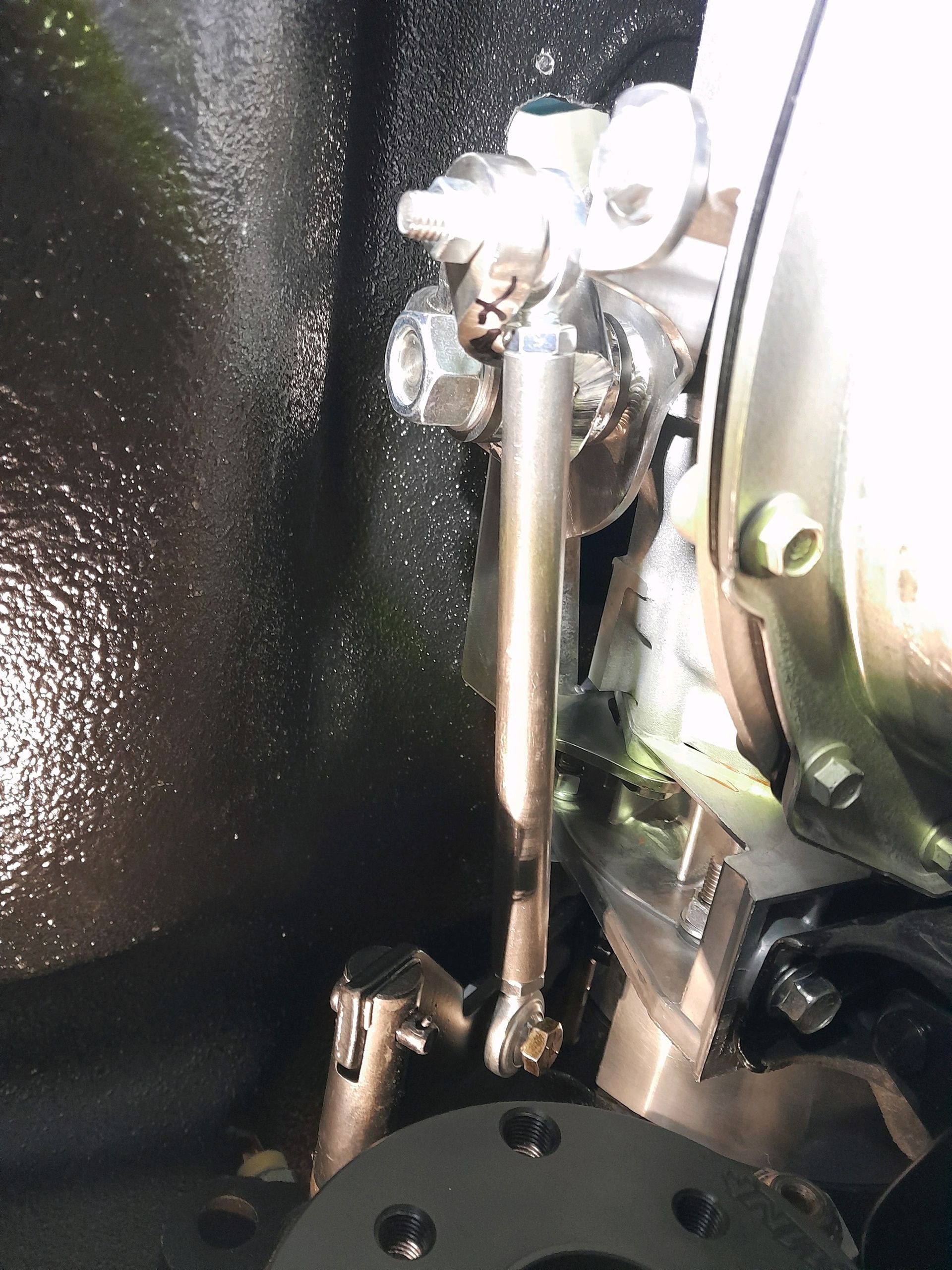 Close-up of a metal linkage and spring assembly inside a mechanical device.