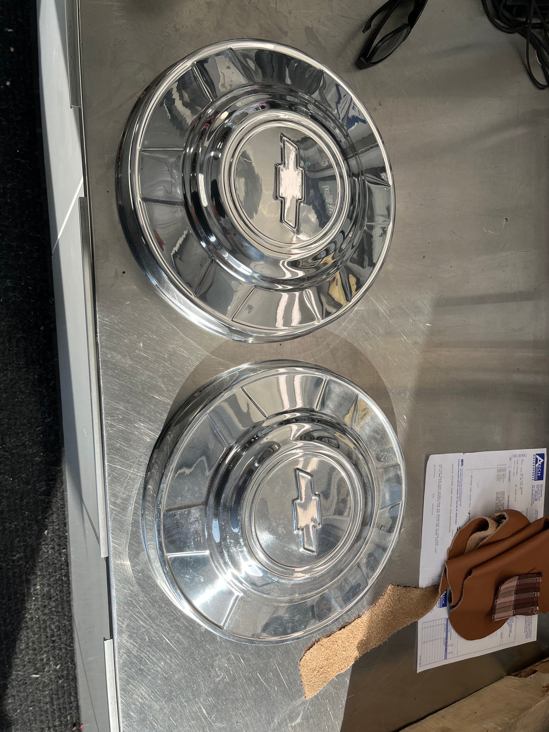 Two shiny silver plates with brown food on a tray, next to a card on a countertop.