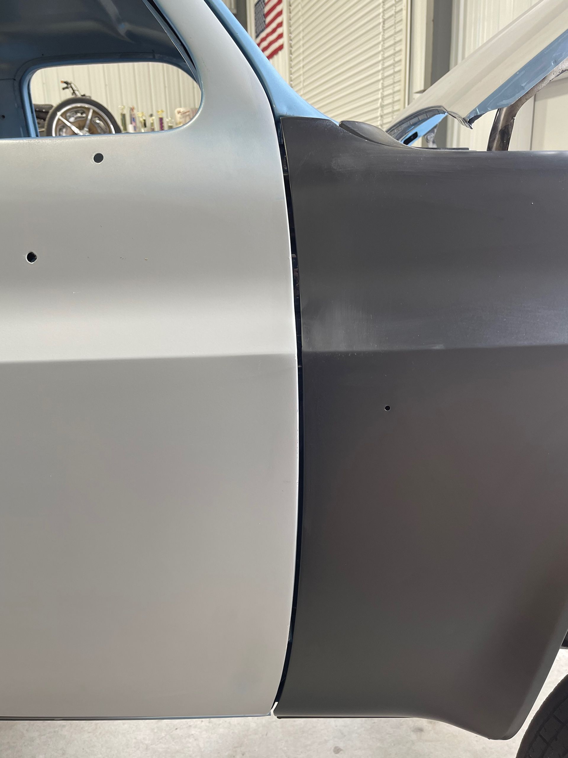 Close-up of a gray and black aircraft fuselage seam in a hangar