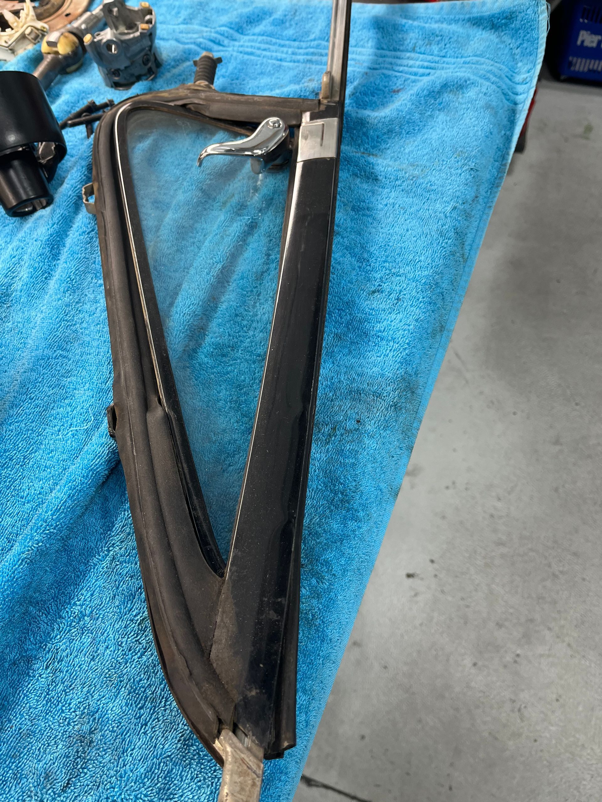 Black U-shaped metal tool or bracket with cables on a blue towel, close-up.