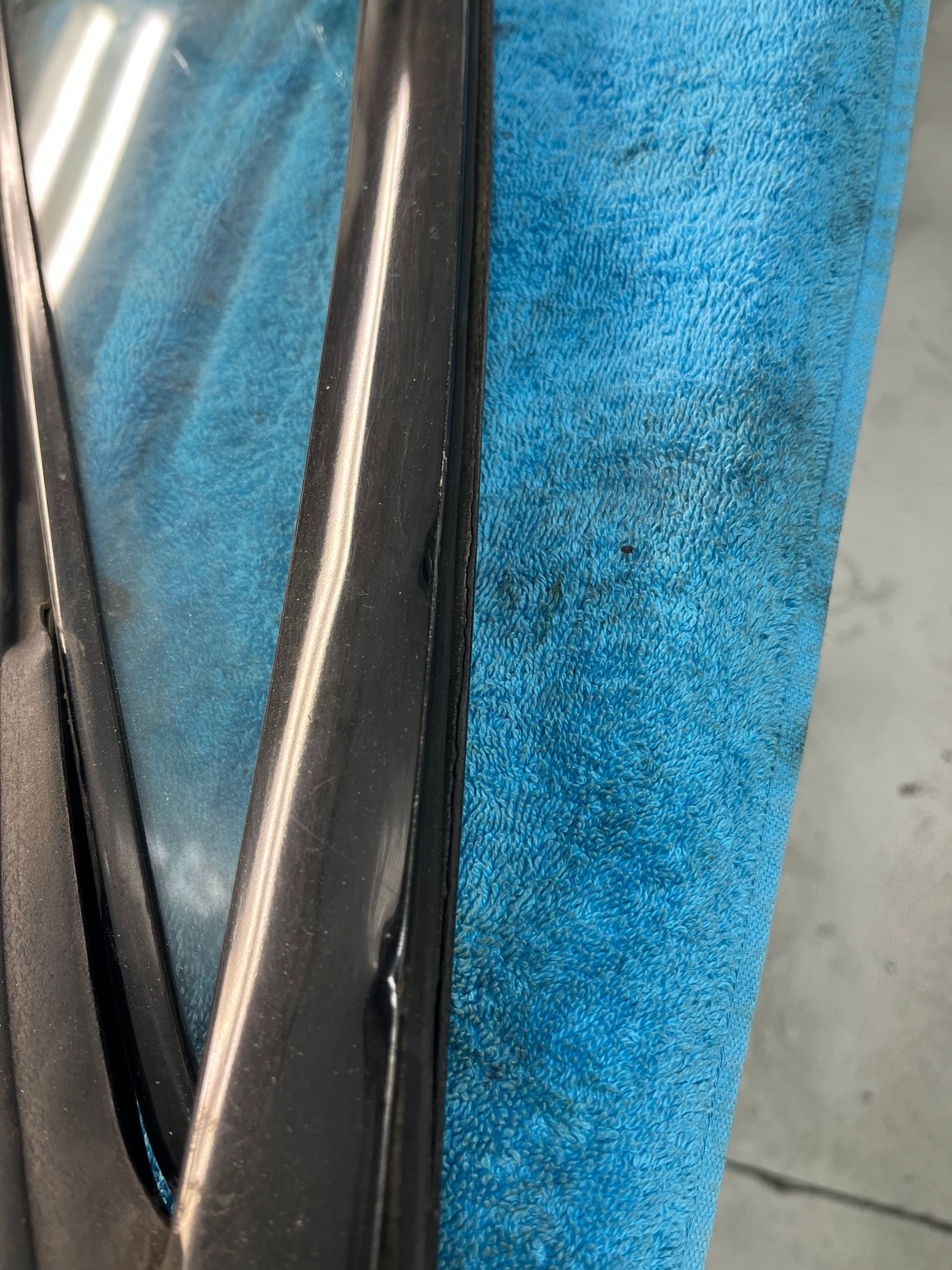 Close-up of blue fabric and black trim on a car seat or upholstery.