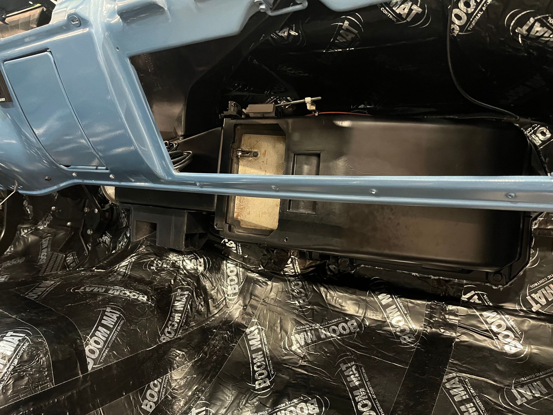 Blue model aircraft fuselage on a stand, with exposed black interior components and wiring