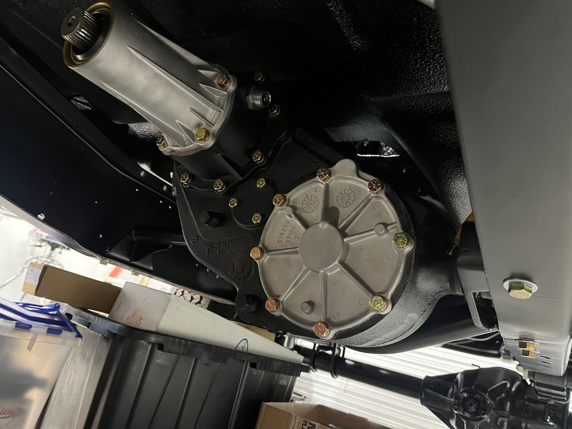 Close-up of a black mechanical assembly with circular gear housing and a transparent motor casing underneath.