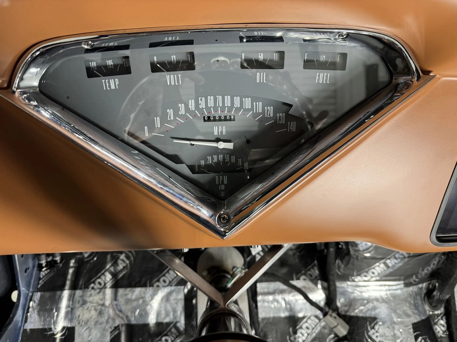Close-up of a car’s triangular rear window and surrounding bronze bodywork, with visible interior frame details