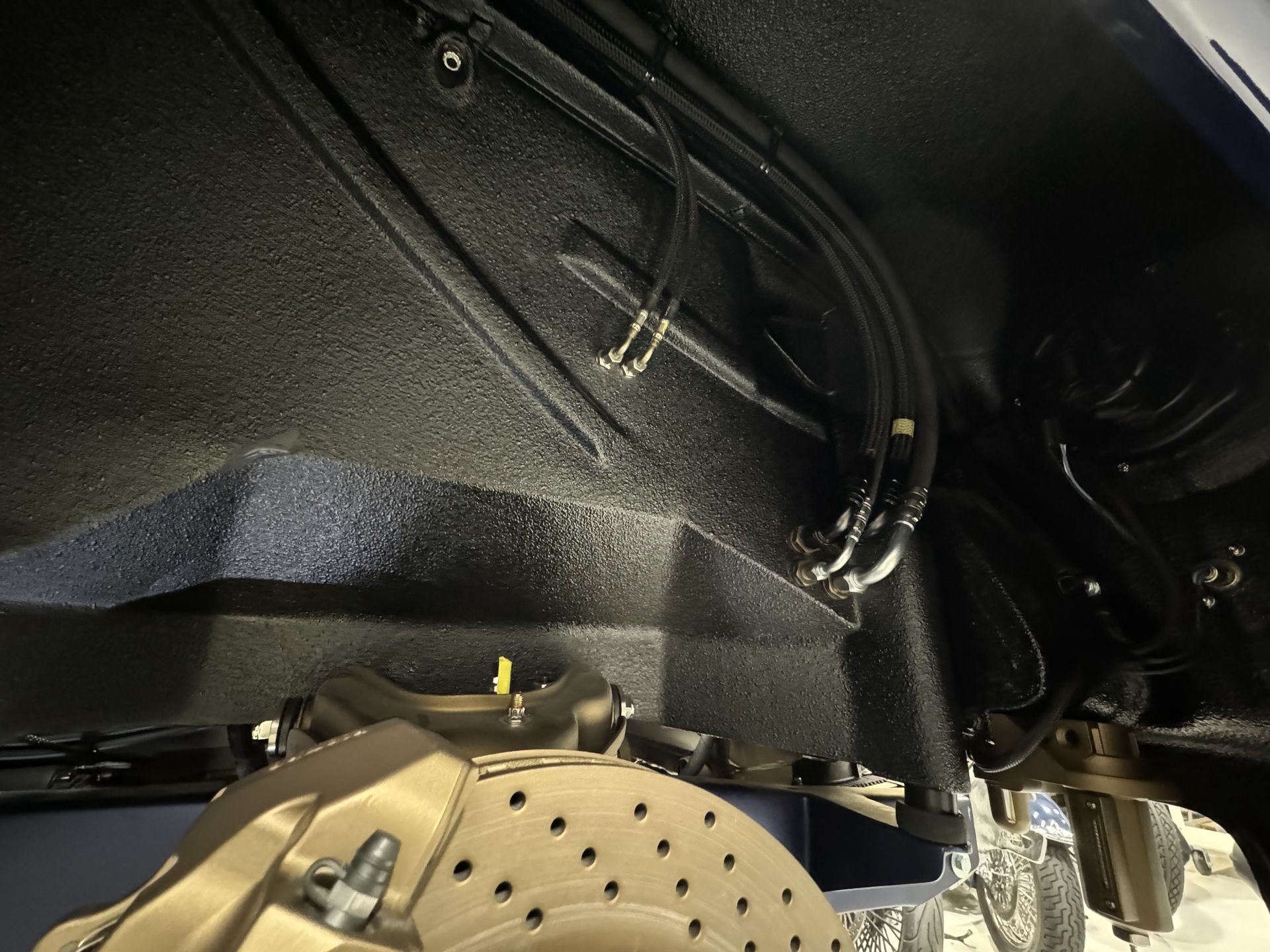 Close-up of a car wheel well with suspension components and a brake rotor visible