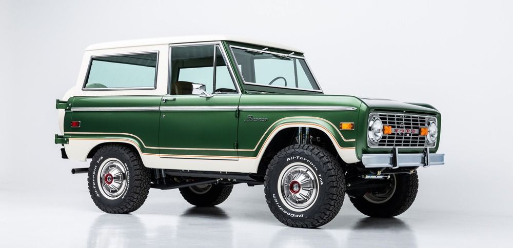 Classic green off-road SUV with a white roof, side view on a white background