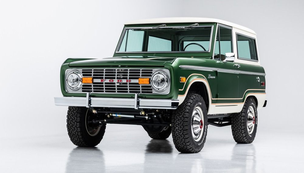 Vintage green-and-white off-road SUV on a white studio background