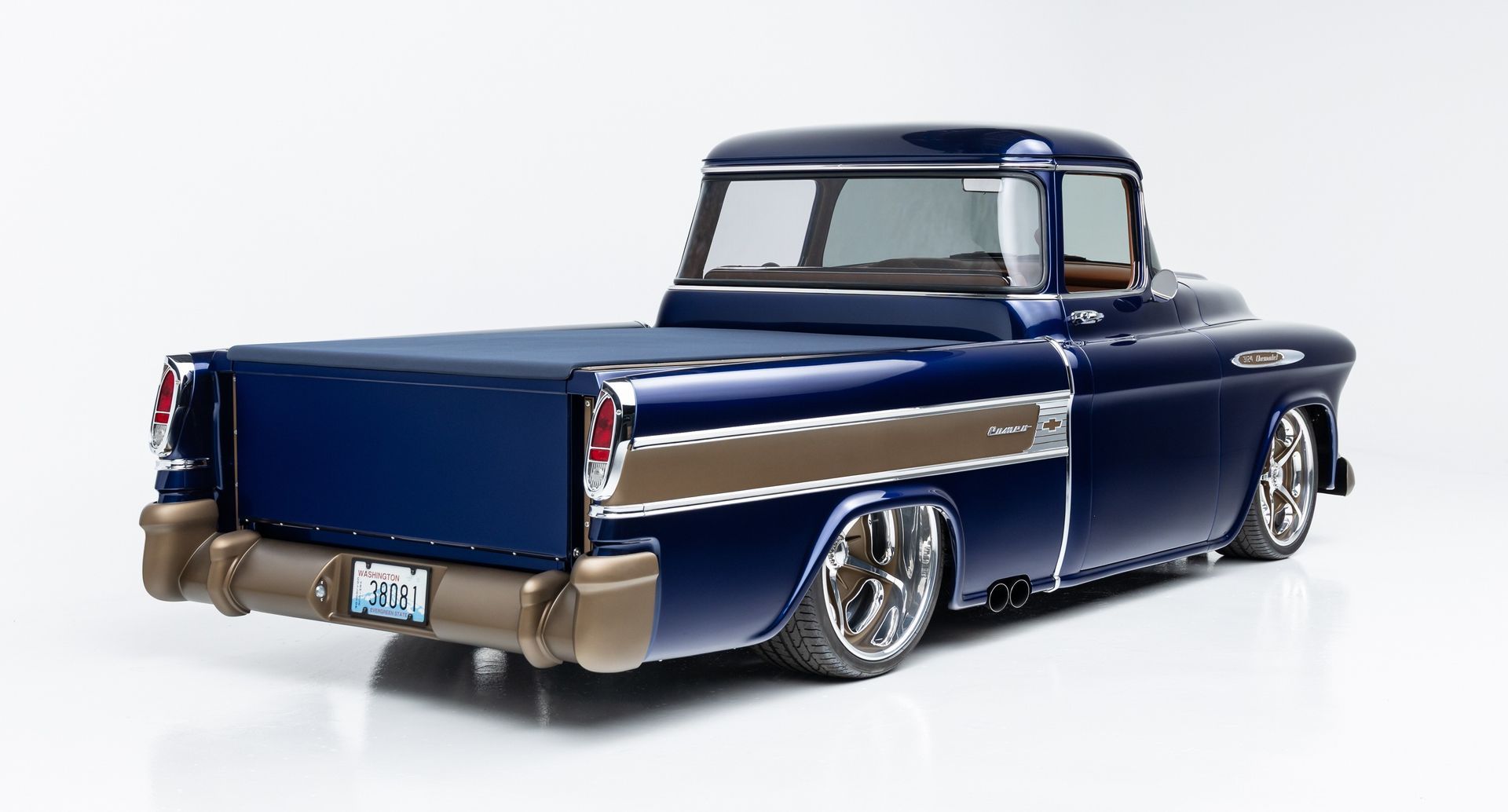 Classic dark blue lowrider pickup truck with chrome trim and white roof on a white background