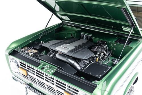 Open green car hood showing the engine compartment