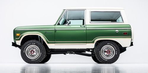 Side view of a green and white vintage off-road SUV on a white background