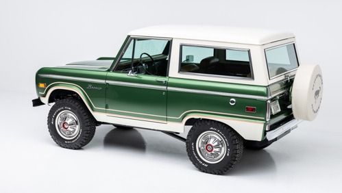 Green and white vintage SUV on a white background, shown in side view