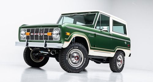 Green vintage off-road SUV on a white studio background