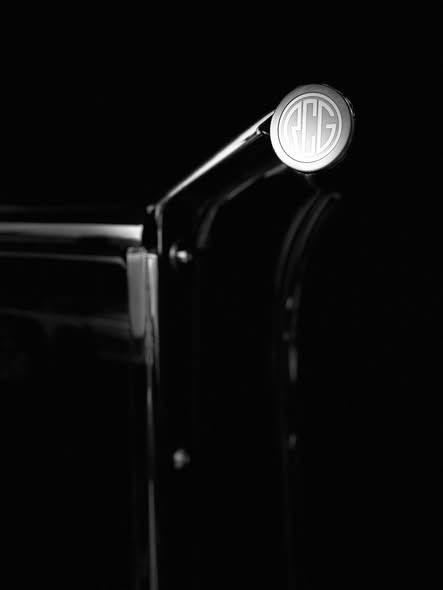 Close-up of a black car door and chrome side mirror against a dark background