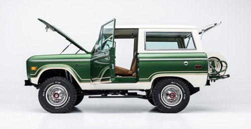 Green vintage SUV in side view with hood and driver door open, white roof, on a white background