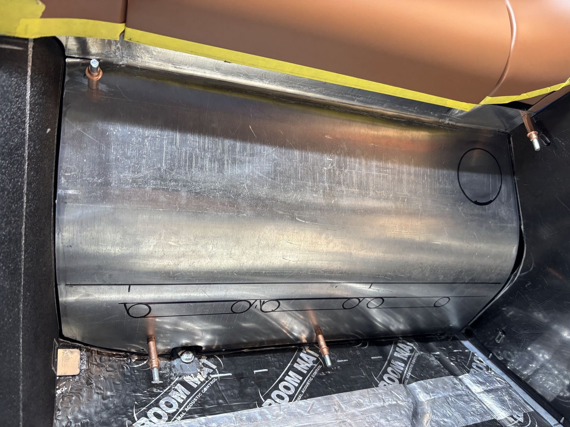 Interior of a vehicle with a black metal panel and exposed insulation under the dashboard