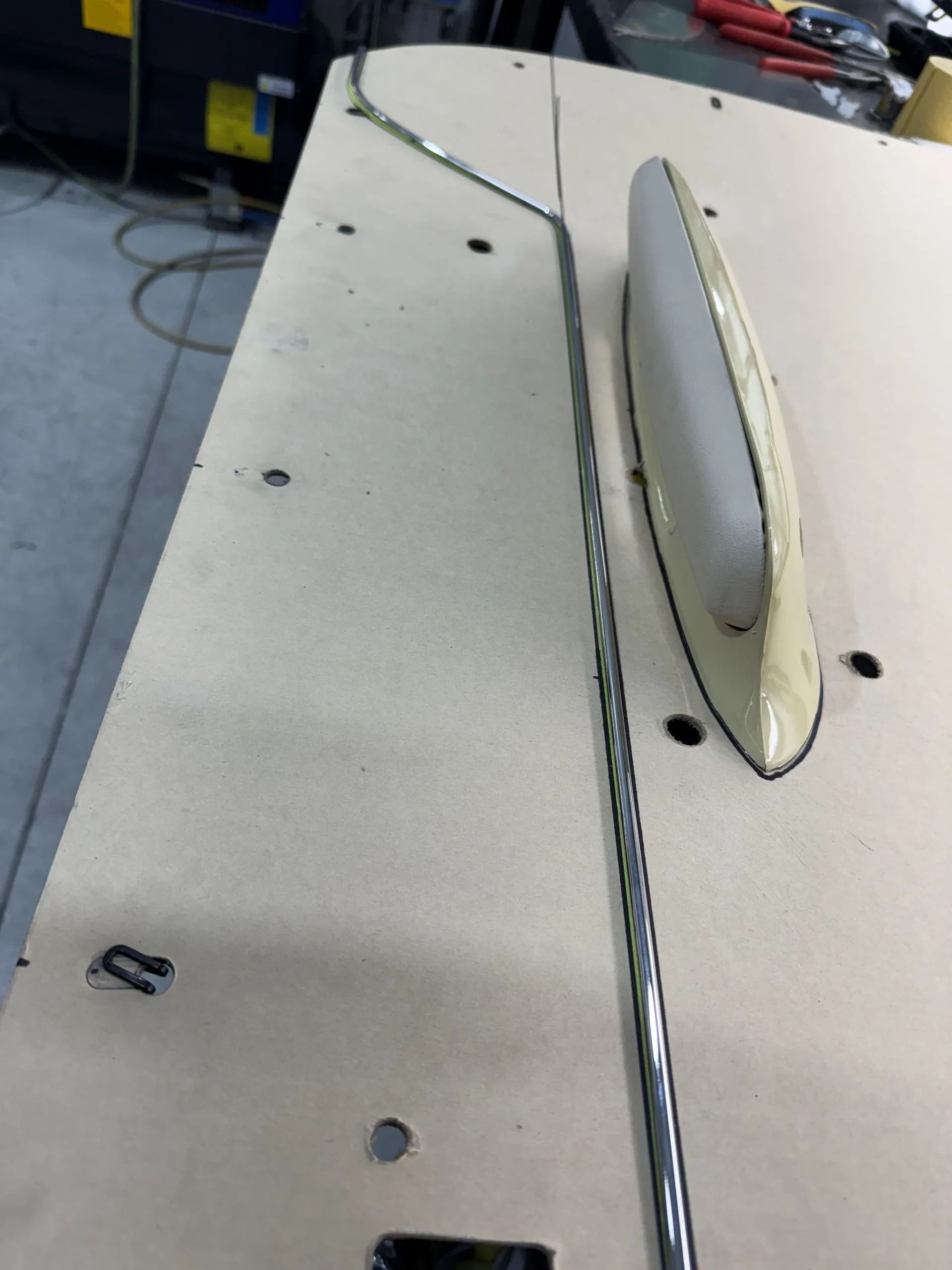 Close-up of a gray metal surface with a long slot and a protruding handle, likely a machine top.
