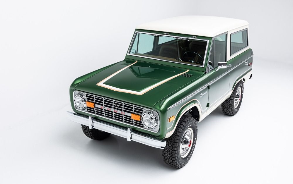 Classic green-and-white vintage off-road SUV on a white background