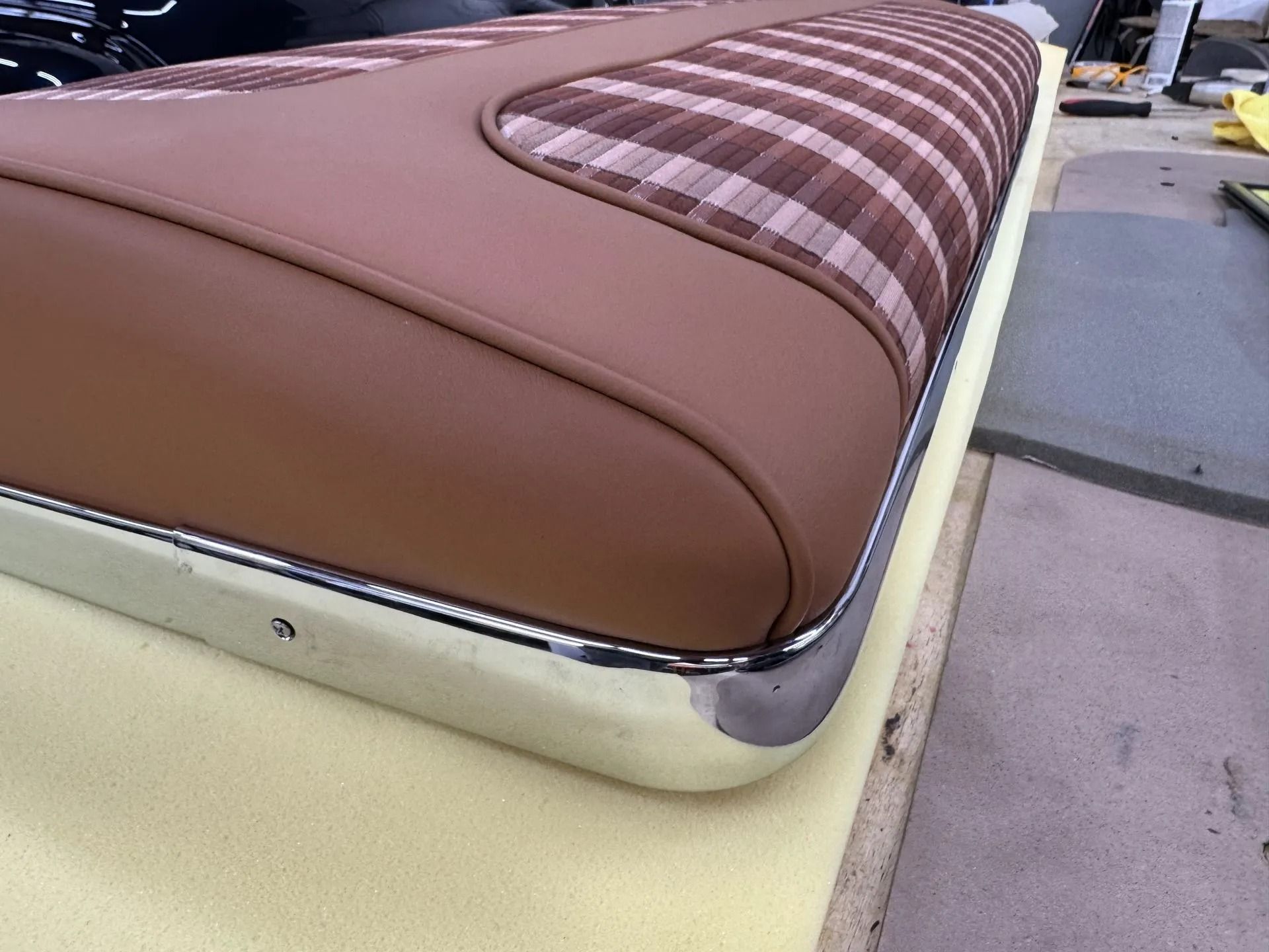Brown and plaid upholstered bench seat with chrome trim on a pale yellow base