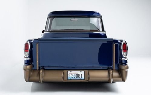 Rear view of a blue classic pickup truck on a white studio background