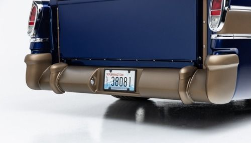 Rear of a blue classic car with chrome bumper and tan lower trim, shown with a visible license plate.