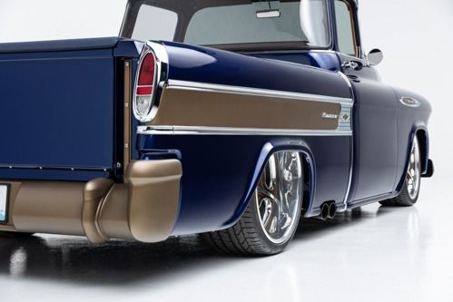 Classic blue pickup truck with chrome details, viewed from the rear on a white studio background